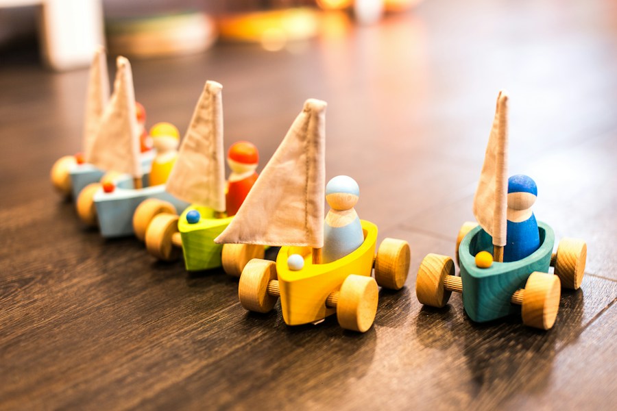 Colourful wooden sailboats with wheels and small sailor figures
