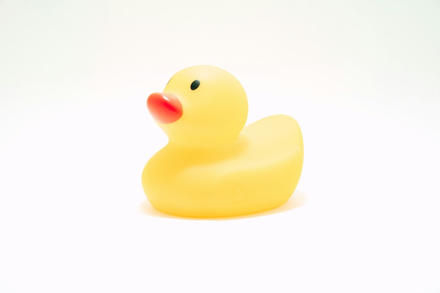 Yellow bath duck with an orange beak on a white background