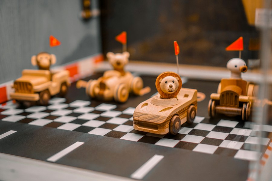 Wooden racing vehicles with animal drivers on a chequered track